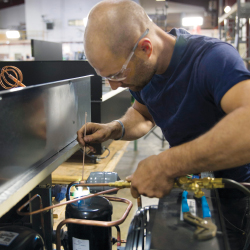 JSI craftsman working on refrigeration display